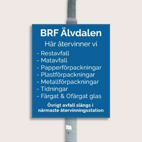 Blå skylt på en stolpe vid en BRFs återvinningsplats.